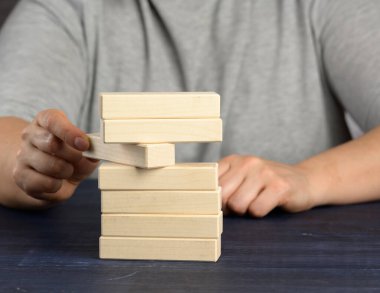 Elim kazıktan ahşap bir blok çıkarıyor. Denge konsepti, durum kontrolü, kapatın