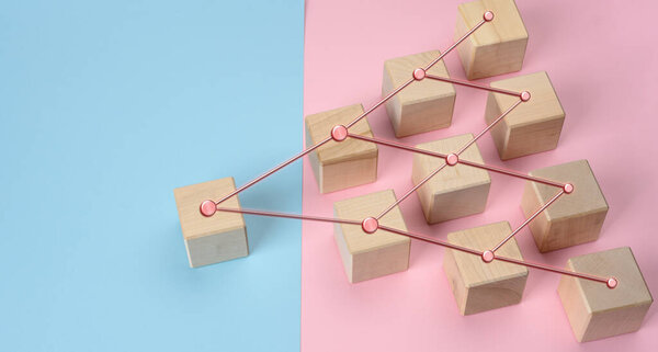 wooden blocks on a pink blue background, hierarchical organizational structure of management, effective management model in the organization, top view