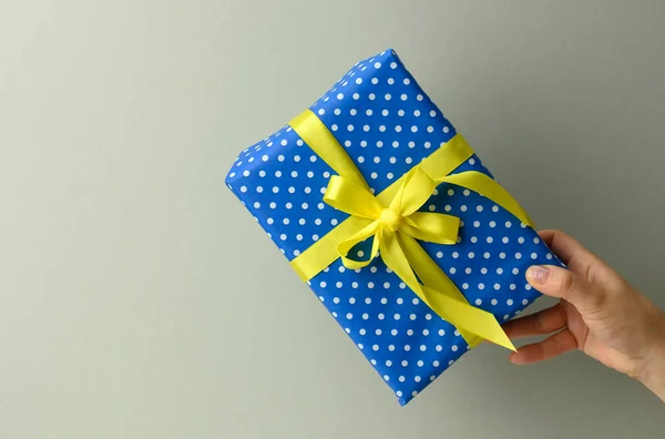 Mão Feminina Estão Segurando Uma Caixa Presente Azul Fundo Cinza — Fotografia de Stock