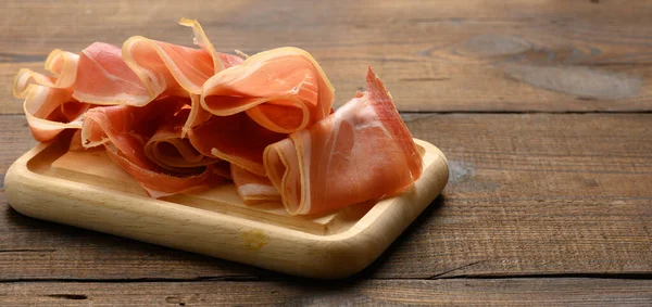 Szeletelt Vékony Szeletek Prosciutto Fából Készült Barna Fórumon Asztal Háttér — Stock Fotó