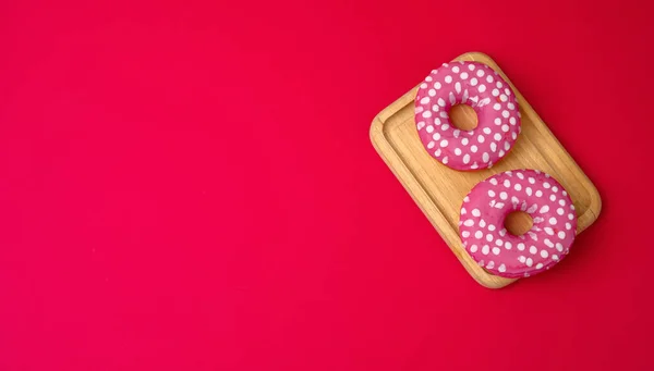 Drie Gebakken Ronde Donuts Roze Glazuur Een Rode Achtergrond Kopieer — Stockfoto