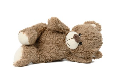 Şirin kahverengi oyuncak ayı beyaz izole bir zeminde yatıyor.