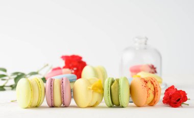 Beyaz bir masada fırında makarna ve gül tomurcukları, gurme badem unu tatlısı, yakın plan.