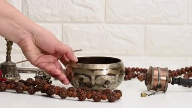 Tibet ritüelleri meditasyon ve dinlenme için beyaz bir masa üzerinde dini eşyalar, bir şarkı kasesi. Ruh sağlığı ve alternatif tıp