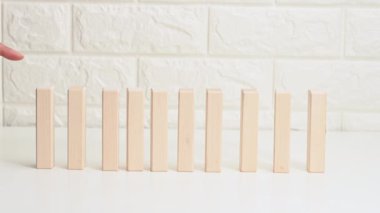 Beyaz bir masanın üzerine düşen tahta bloklar, parmak ilk bloğu itiyor. Zayıf takım konsepti, akıl sağlığı. Dış çevrenin zayıflamış bir insan üzerindeki etkisi