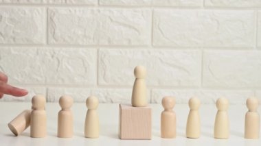 Elleri, insanların tahta figürlerini itiyor, farklı yönlere düşüyorlar. Bir insan üzerinde psikolojik baskı kavramı, tükenme. Hakimiyet, baskı ve rakiplerin ortadan kaldırılması