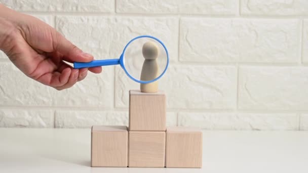 Hand Blue Magnifying Glass Examines Unique Talented Wooden Men Employee — Stock video