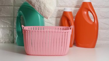 Kadın eli temiz havlu katlar. Plastik bir sepetin içinde, beyaz bir masada, günlük ev rutininde.