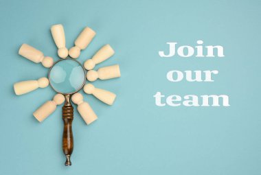 Ahşap adamlar ve mavi arka planda büyüteç. İşe alım konsepti, yetenekli ve yetenekli çalışanlar arayışı, kariyer gelişimi. Takımımıza katıl.