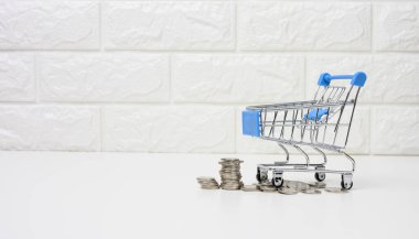 Beyaz bir masada metal tramvay ve bozuk para. Tasarruf kavramı, indirimler, düşük satın alma gücü