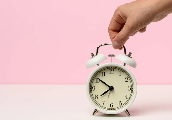 Mão Feminina Segura Despertador Metal Branco Uma Mesa Branca Tempo — Fotografia de Stock