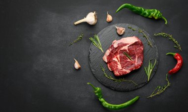 Biberiyeli çiğ sığır pirzolası, siyah bir masada kekik.