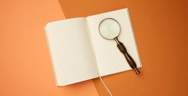 Otevřený Notebook Prázdnými Listy Dřevěnou Lupou Oranžovém Pozadí Horní Pohled — Stock fotografie