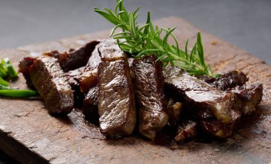 Kızarmış sığır pirzolası parçalanmış. Eskimiş kahverengi bir kesim tahtasıyla, nadir bulunan bir eşarpla. İştah açıcı biftek. 