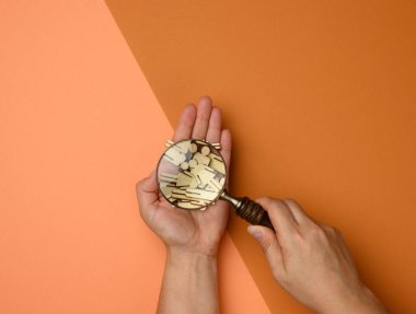 Tahta adamlar ve kahverengi arka planda büyüteç. İşe alım konsepti, yetenekli ve yetenekli çalışanların aranması, kariyer gelişimi