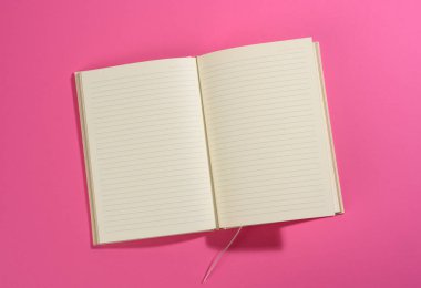 Pembe arkaplanda boş beyaz sayfaları olan bir defter aç, üst görünüm