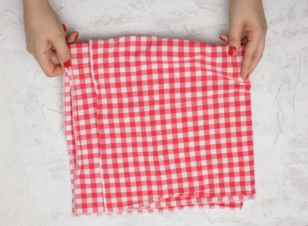 Twee Vrouwelijke Handen Houden Een Verfrommeld Wit Rood Geruite Textiel — Stockfoto