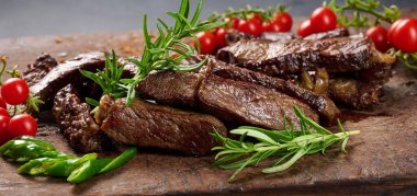 Kızarmış biftek parçalarını eski kahverengi bir doğrama tahtasıyla parçalara ayırdım. İyi iş çıkardın. İştah açıcı biftek. 