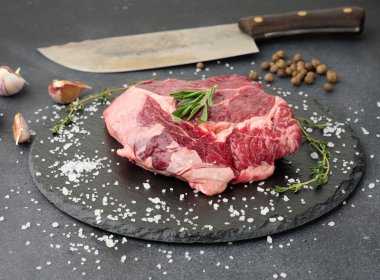 Biberiyeli çiğ sığır pirzolası, siyah bir masada kekik.