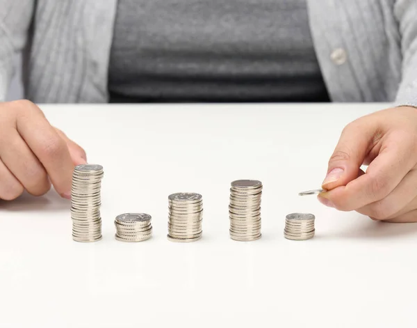 woman\'s hand puts money on a pile of money. Money saving concept.