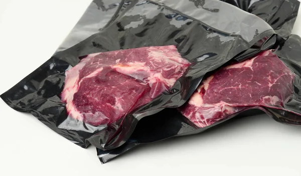 piece of fresh beef meat packed in a vacuum plastic bag, top view