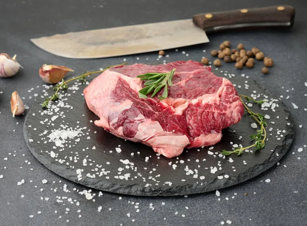 Biberiyeli çiğ sığır pirzolası, siyah bir masada kekik.