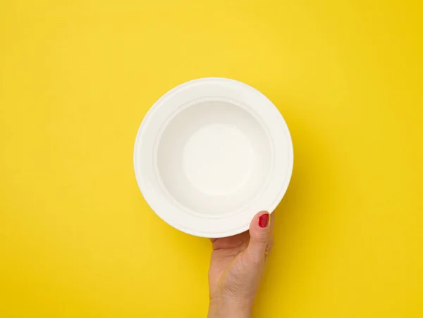 Female Hand Holding Empty Plate Yellow Background Top View — Stock Photo, Image