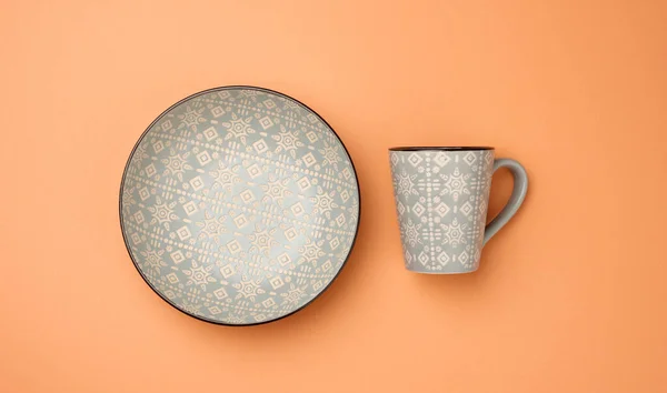 空的灰色陶瓷汤盘和橙色底座上的空杯子 顶视图 — 图库照片