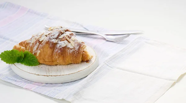用糖撒在木板上的烤羊角面包 白色亚麻餐巾 — 图库照片