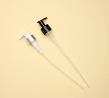 Cam için bir pipet ve açık sarı zemin üzerinde sıvı olan plastik şişeler.