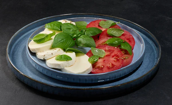 Dilimlenmiş taze domatesli klasik Caprese salatası.