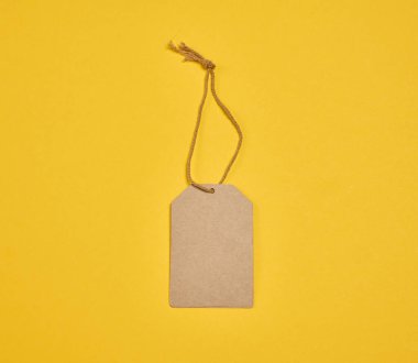 Sarı arkaplan üzerine kurulu boş bir el işi dikdörtgen etiketi. Fiyat etiketi, hediye etiketi ya da el işi projesi için bir model.