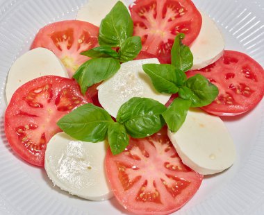 Dilimlenmiş taze domatesli klasik Caprese salatası.
