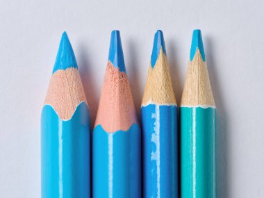 Beyaz arka planda sivri uçlu mavi tahta kalemler, yakın plan.