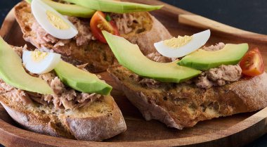 Tahta üzerinde ton balığı, avokado, yumurta ve domates, aperatif.