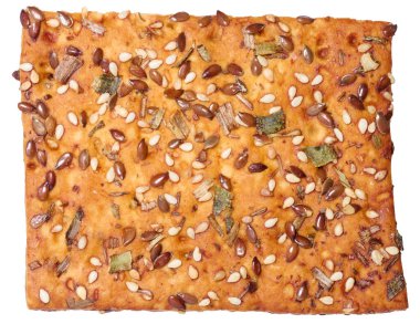 Keten ve susam tohumları serpiştirilmiş çıtır ekmek, kurutulmuş otlar, altın fırınlanmış kabuk. İzole edilmiş arkaplan.