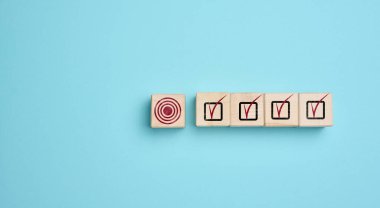 Hedefi olan tahtadan küpler ve tamamlanmış görevler, hedeflere ulaşma, bir planı uygulama veya bir stratejiyi başarıyla uygulama kavramı.