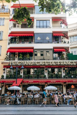 Güzel, Fransa - 14 Haziran 2025 Jean Medecin Bulvarı 'ndaki Le Grand Cafe de France açık masalarda oturan insanlarla