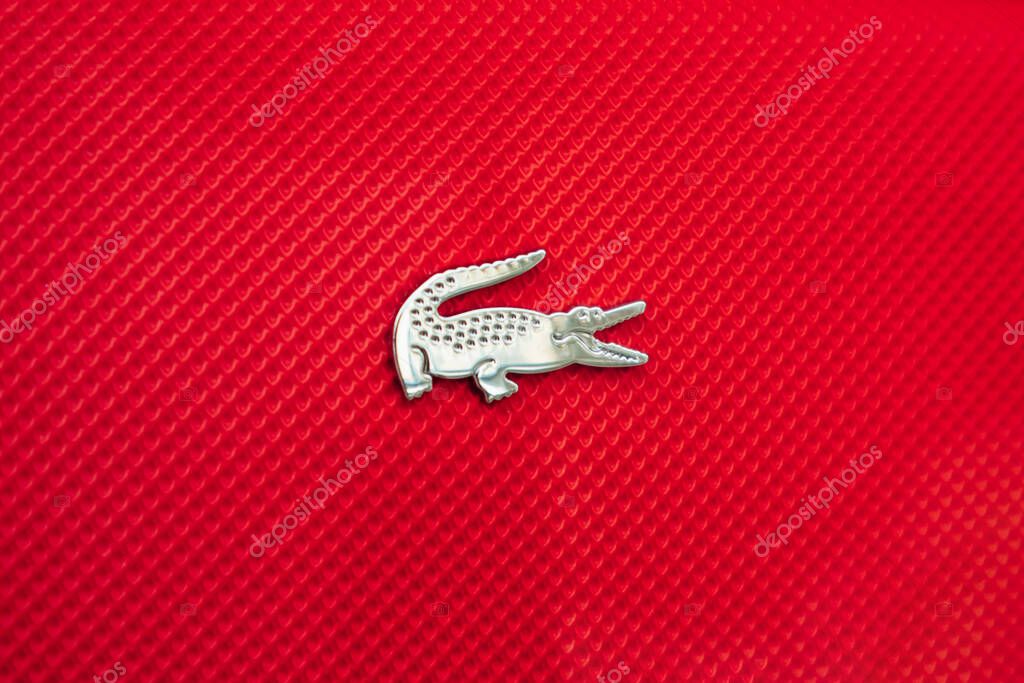 Nice, France - June 14, 2025: Close-up of Lacoste crocodile logo on red textured polo shirt in boutique