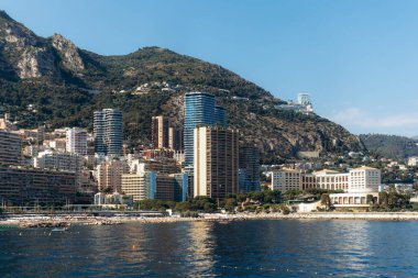 Monako 'nun La Rousse ilçesinin Mareterra çevre bölgesinden arka planda deniz kenarı binaları ve tepeleri ile manzarası