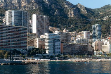 Monako 'nun La Rousse ilçesinin Mareterra çevre bölgesinden arka planda deniz kenarı binaları ve tepeleri ile manzarası
