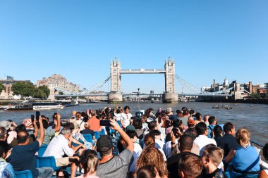 Londra, İngiltere - 11 Ağustos 2022: Londra şehir merkezinden Tower Bridge 'e yaklaşan turist dolu gezi teknesi