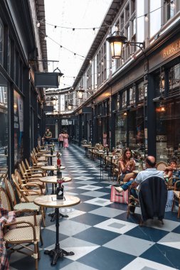 Cardiff, Galler - 15 Ağustos 2022: Cardiff 'teki tarihi alışveriş merkezlerinden birinde çiçekli şık kafe masaları ve sandalyeler