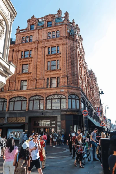 Londra, İngiltere - 13 Ağustos 2022: Harrods 'un ünlü mağazası tarihi terracotta cephesi ve Knightsbridge' deki yoğun girişi