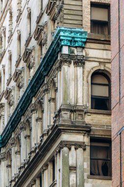 Montreal, Kanada - 11 Ağustos 2025: Montreal, Quebec şehir merkezinde süslü taş işçiliği ve yeşil bakır detayları ile tarihi bina cephesi