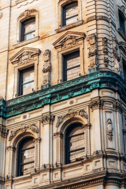 Montreal, Kanada - 11 Ağustos 2025: Montreal, Quebec şehir merkezinde süslü taş işçiliği ve yeşil bakır detayları ile tarihi bina cephesi