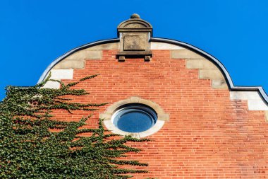Tarihi kırmızı tuğlalı itfaiye istasyonunun dekoratif kapısı ve yuvarlak penceresi Montreal histoire Merkezi, mavi gökyüzüne karşı.