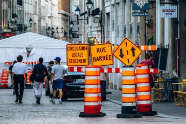 Montreal, Kanada - 11 Ağustos 2025: Turuncu Rue Barree ve yerel trafik işaretli inşaat bölgesi, Montreal şehir merkezinde kapalı caddelerde yürüyen insanlar