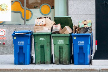 Montreal, Kanada - 11 Ağustos 2025: Montreal şehir merkezindeki mukavva binanın dışındaki çöp bidonları
