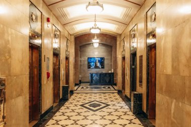 Montreal, Kanada - 11 Ağustos 2025: Aldred Binası 'nın içi pirinç, geometrik zemin ve vintage asansörlerle dolu